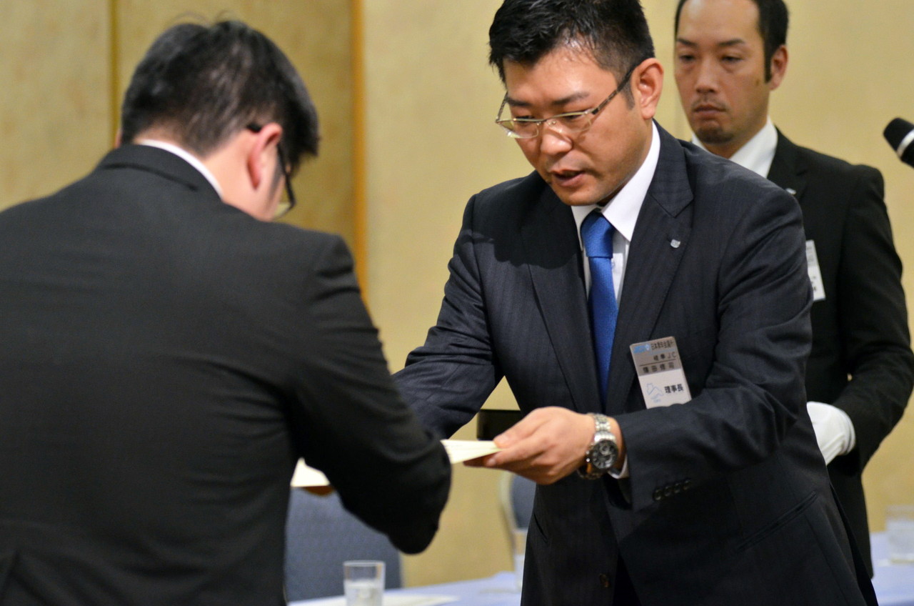 理事長　篠田　修司君より新入会員一人ひとりに入会承認証が授与されました。また、青年会議所メンバーの証であるネームプレートとバッジを付けて頂き、固い握手を交わしました。